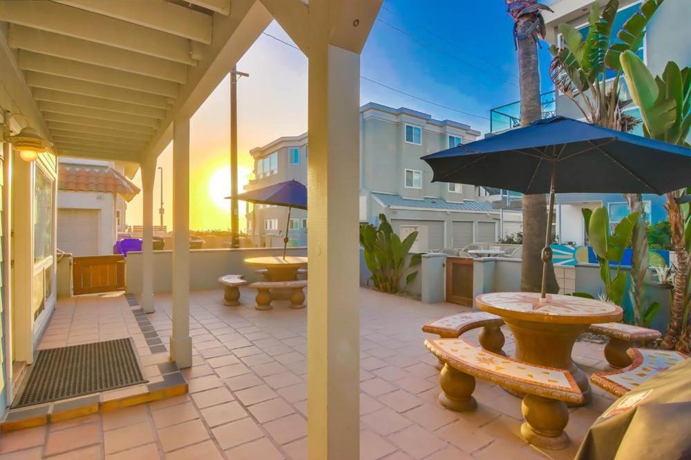 een patio met een tafel, een parasol en banken bij South Shore 1 in San Diego
