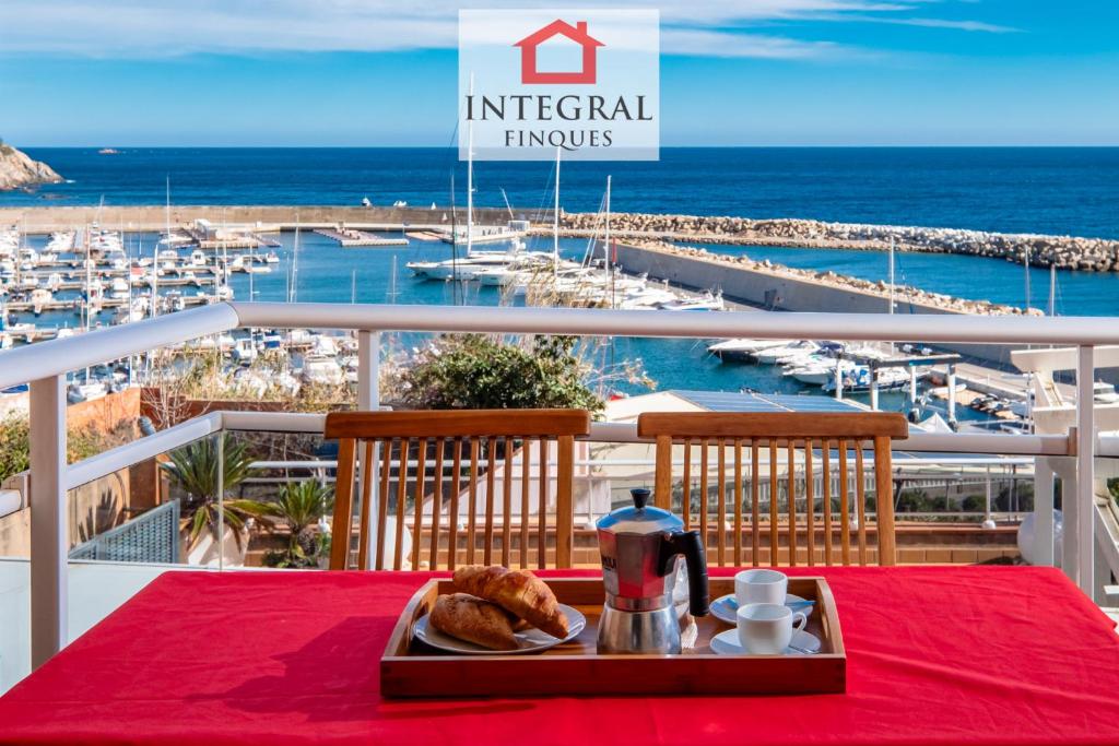 a tray of food on a table with a view of the ocean at Sol i Aire Apartament Palamós in Palamós