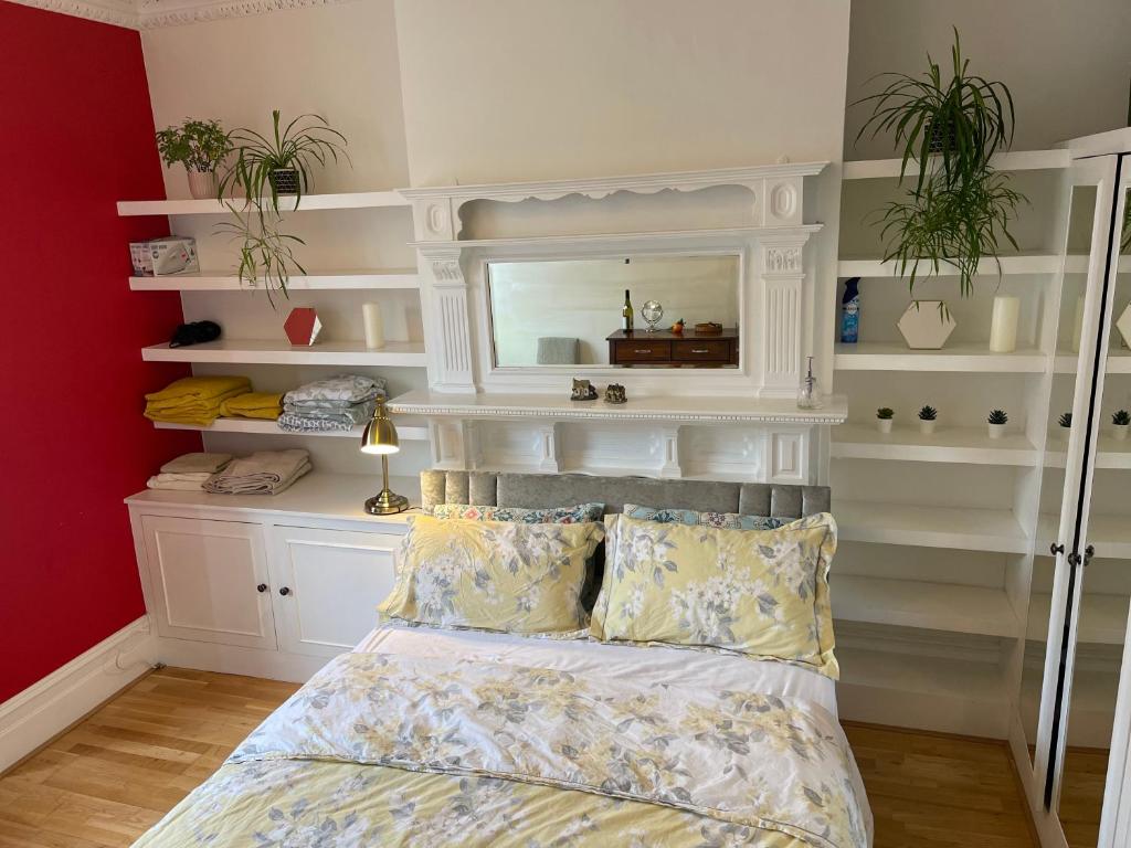 1 dormitorio con 1 cama con espejo y estanterías en 15 min to The Heart of London - Charming 2 bed Apartment, en Londres