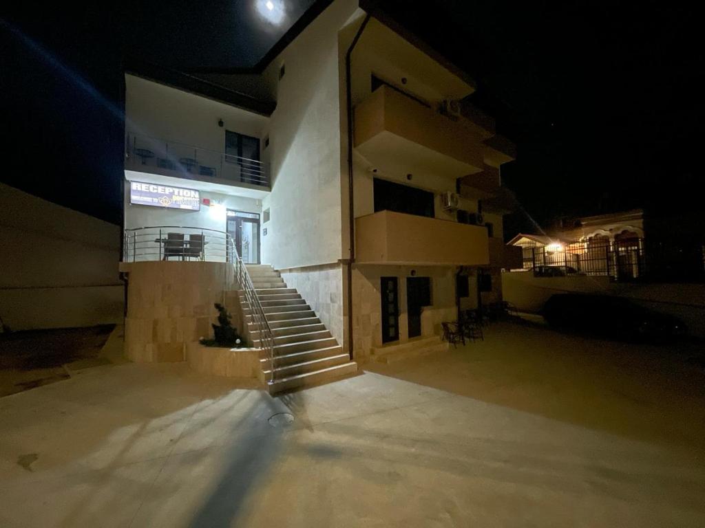 a building at night with a cat sitting on the stairs at Prestige House in Tulcea