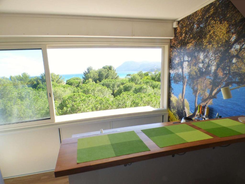 Cette chambre dispose d'une grande fenêtre et d'une table avec une couette. dans l'établissement Vue mer, climatisation, Wifi, plage en face, à La Seyne-sur-Mer