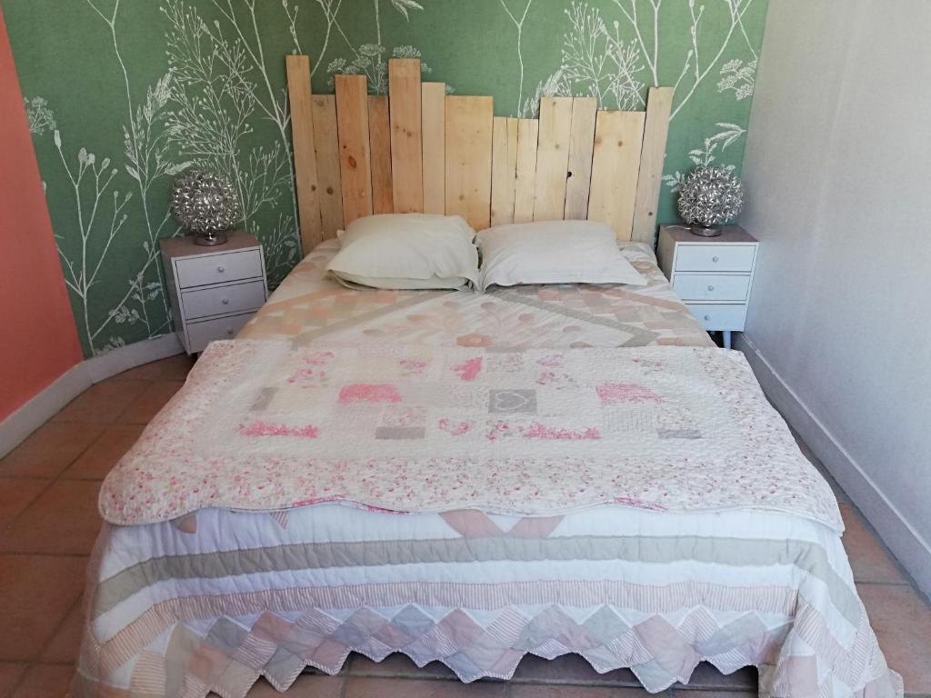 Schlafzimmer mit einem großen Bett mit einem Kopfteil aus Holz in der Unterkunft IMAGINE ... in Beuzeville