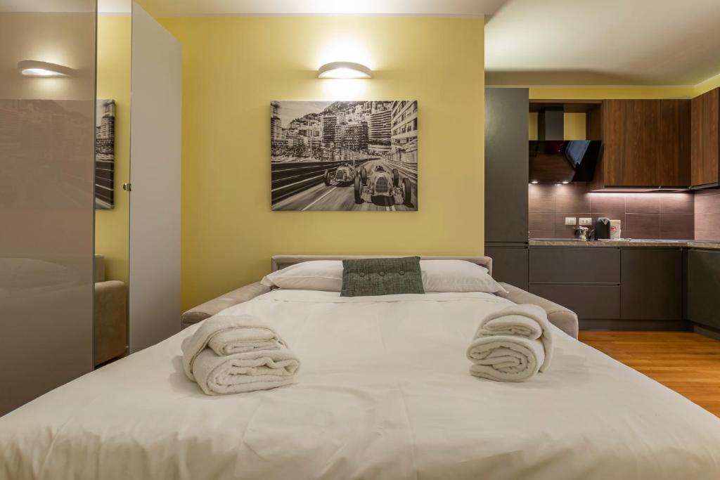 Un dormitorio con una gran cama blanca con toallas. en Xenia Apartments - Elegant studio 10 min from Linate, en Milán