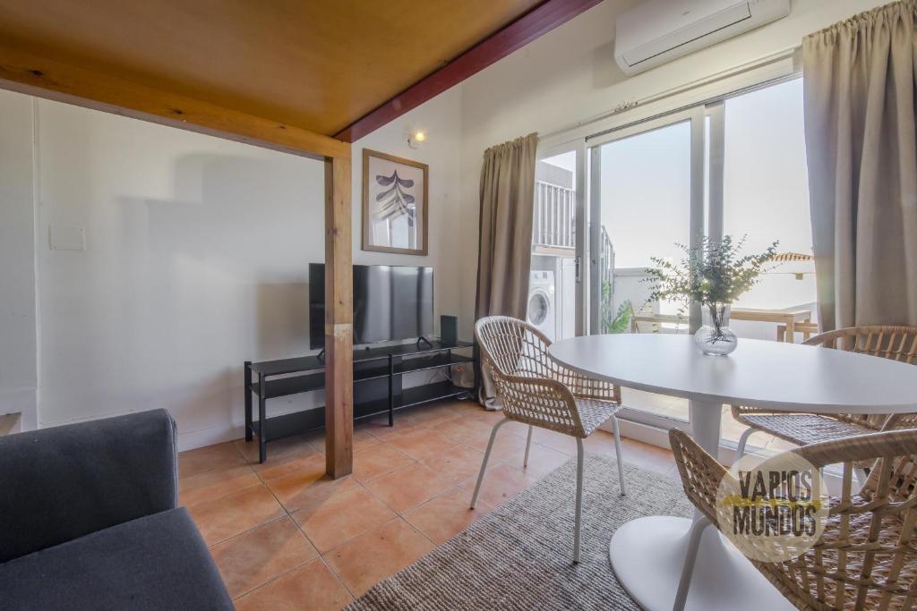 a living room with a table and chairs and a tv at Fabuloso Atico Doble Altura para 3pax en Chueca in Madrid