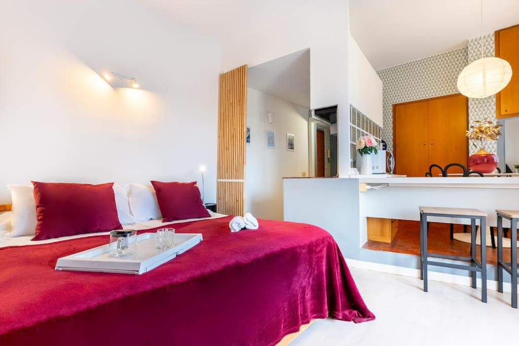 ein Schlafzimmer mit einem roten Bett und einem Tisch darauf in der Unterkunft Appartamento Procaccini - Affitti Brevi Italia in Mailand