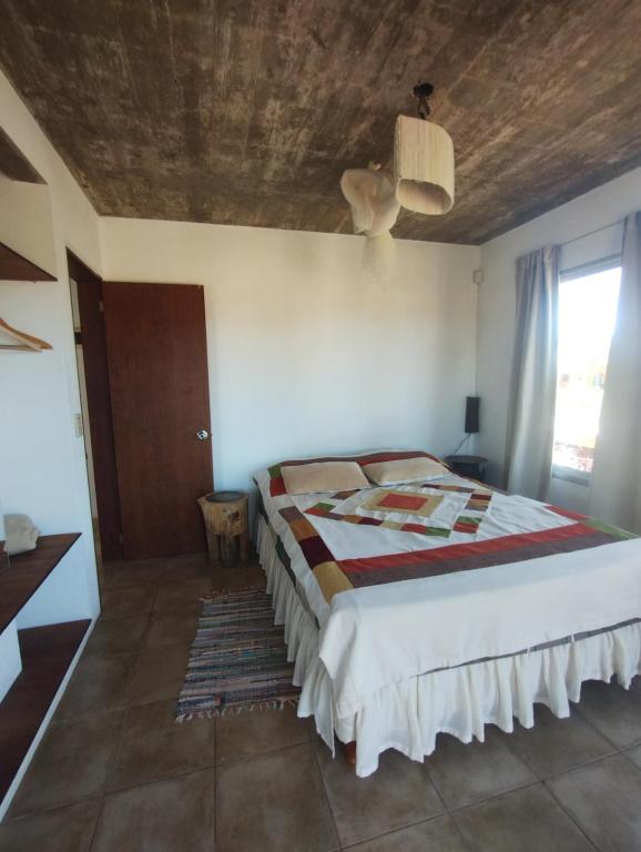 um quarto com uma cama e um tecto em madeira em Iona em Punta Del Diablo