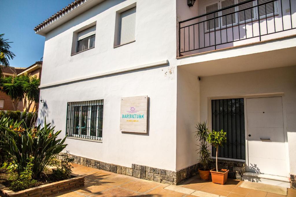 un edificio blanco con plantas delante en BBTK Eco-Hostel en Málaga