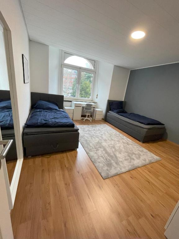 - une chambre avec 2 lits et un tapis dans l'établissement Mavi-Homes-neu saniert mit Balkon III NUR Gesamtvermietung der GANZEN Wohnung für MIND 2 Wochen verfügbar III, à Offenbach-sur-le-Main