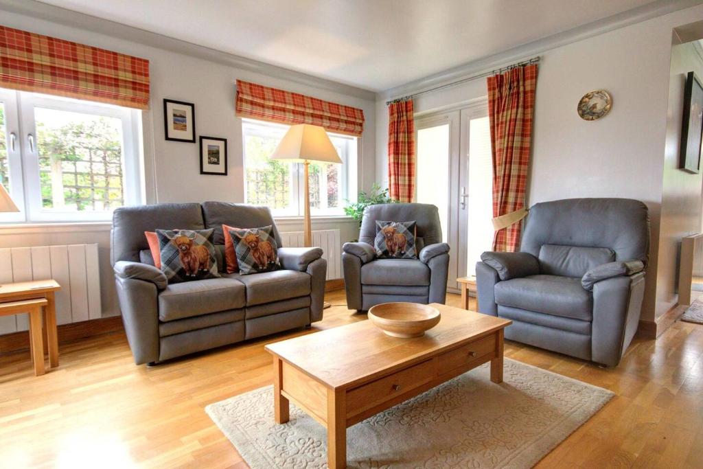 a living room with two chairs and a coffee table at No1 The Links Apartment, Brora in Brora