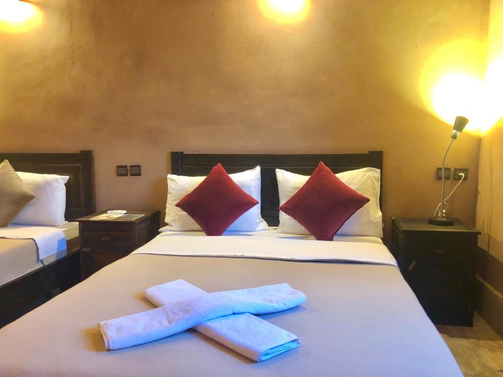 Dos toallas en una cama en una habitación de hotel en Kasbah Ennakb, en Nkob