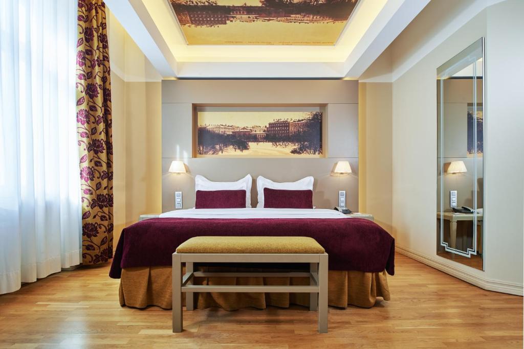 a bedroom with a large bed with purple sheets at Opera Hotel in Riga