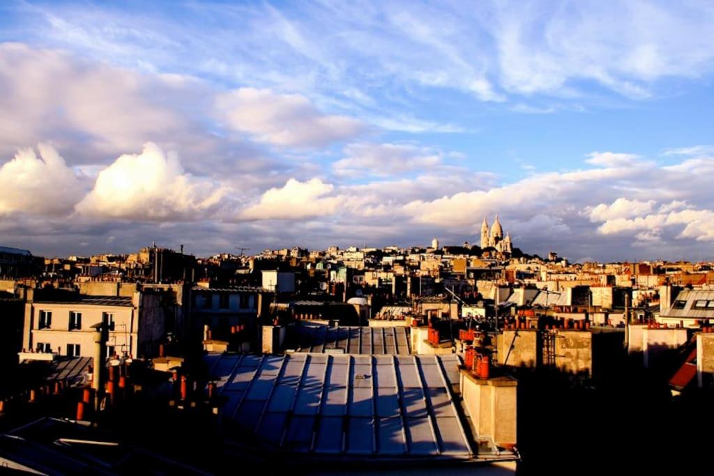 une vue sur une ville avec des bâtiments et un ciel nuageux dans l'établissement Sous le ciel de Paris, petite suite, à Paris