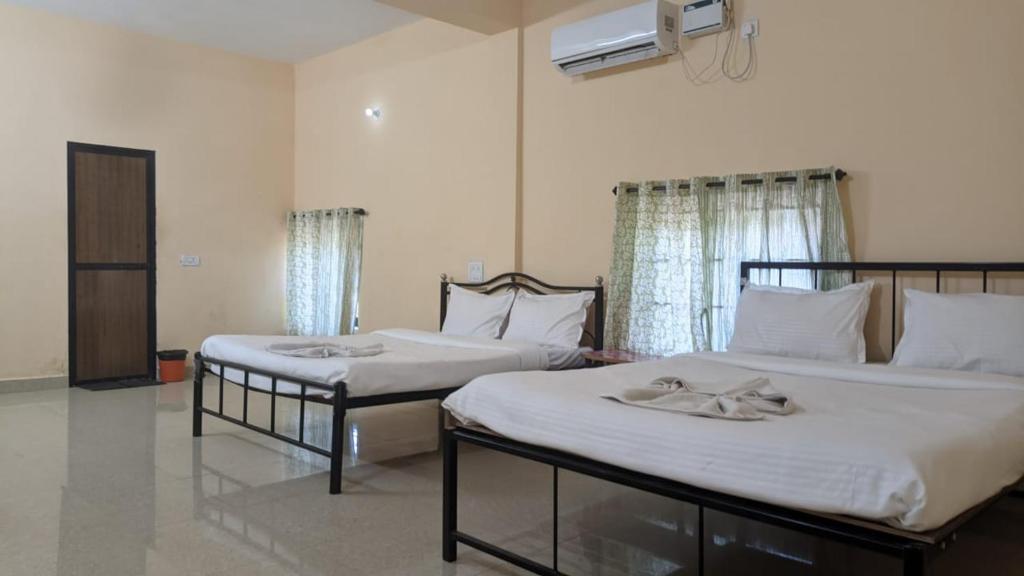 - 2 lits dans une chambre d'hôtel avec des serviettes dans l'établissement HOTEL VITU SIA CALANGUTE BEACH, à Calangute