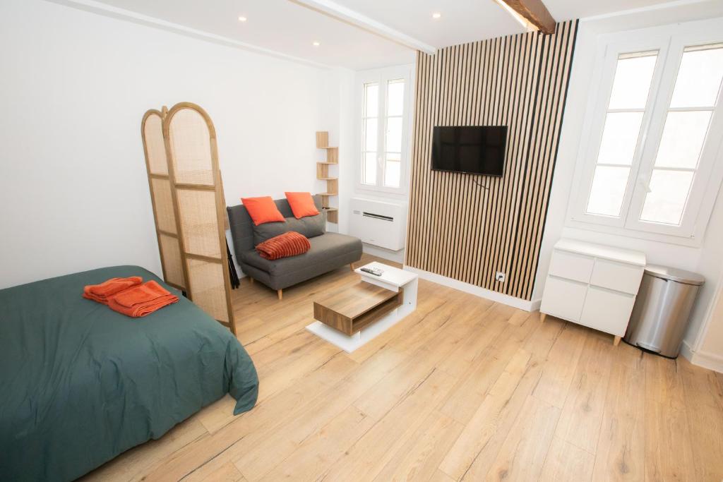 - une chambre avec un lit, un canapé et une télévision dans l'établissement Cozy studio in Villefranche-sur-Mer, à Villefranche-sur-Mer