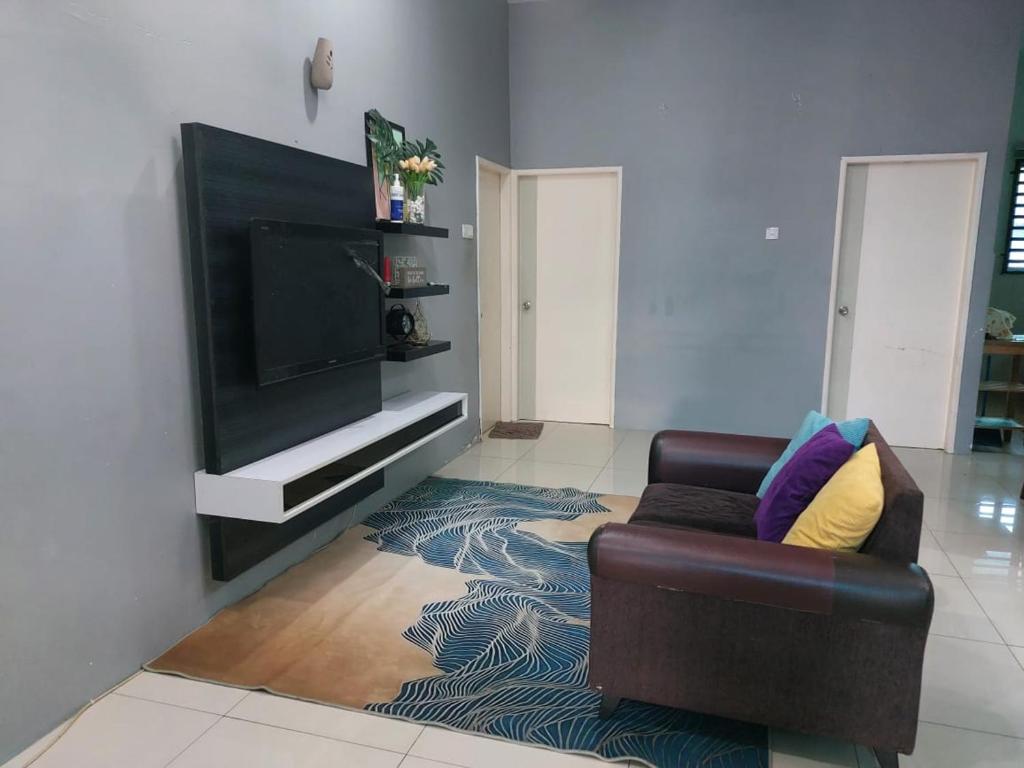 uma sala de estar com um sofá e uma televisão de ecrã plano em Puteri Homestay Sg Petani em Sungai Petani