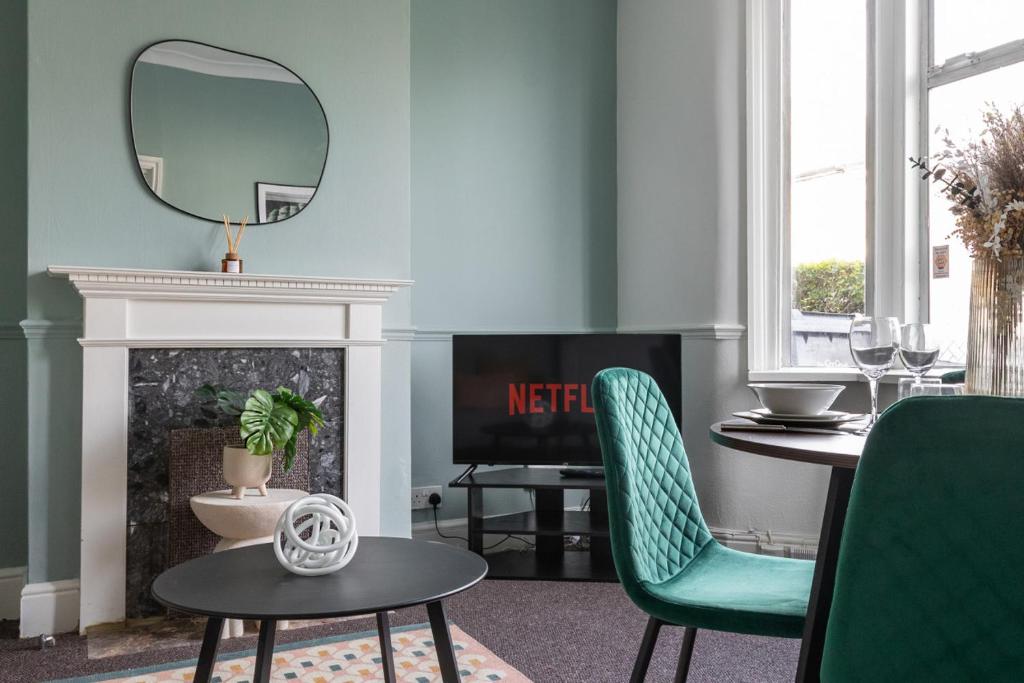 een woonkamer met een tafel en stoelen en een spiegel bij Perry Place - Forest Hill- 3 bed house in Londen