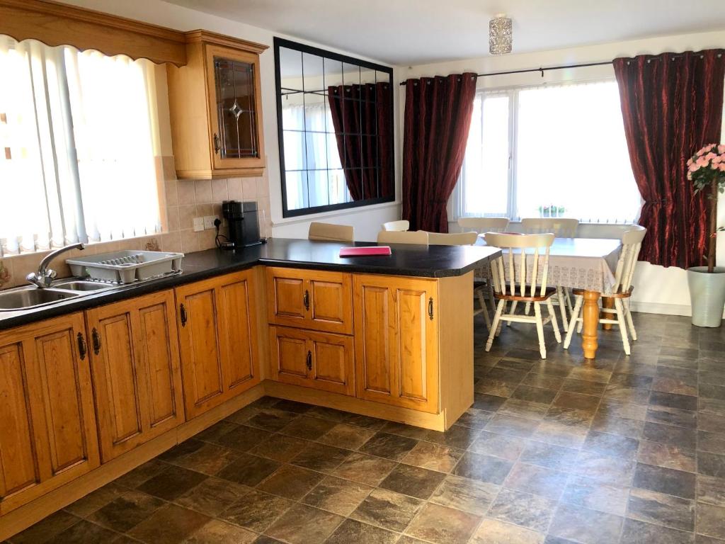 a kitchen with wooden cabinets and a table and a dining room at Cleomack House - Perfect for two in Hilltown
