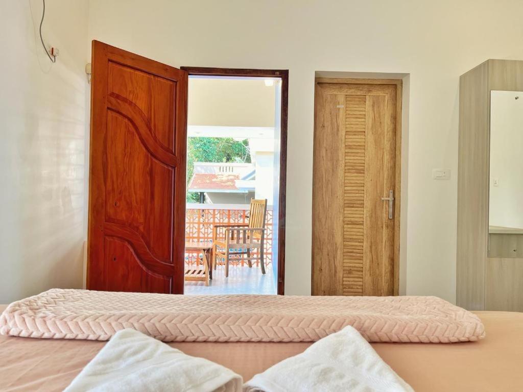 BAVA AC Rooms at Casa de Aadi في فاركَالا: غرفة نوم بسريرين وباب للباحة