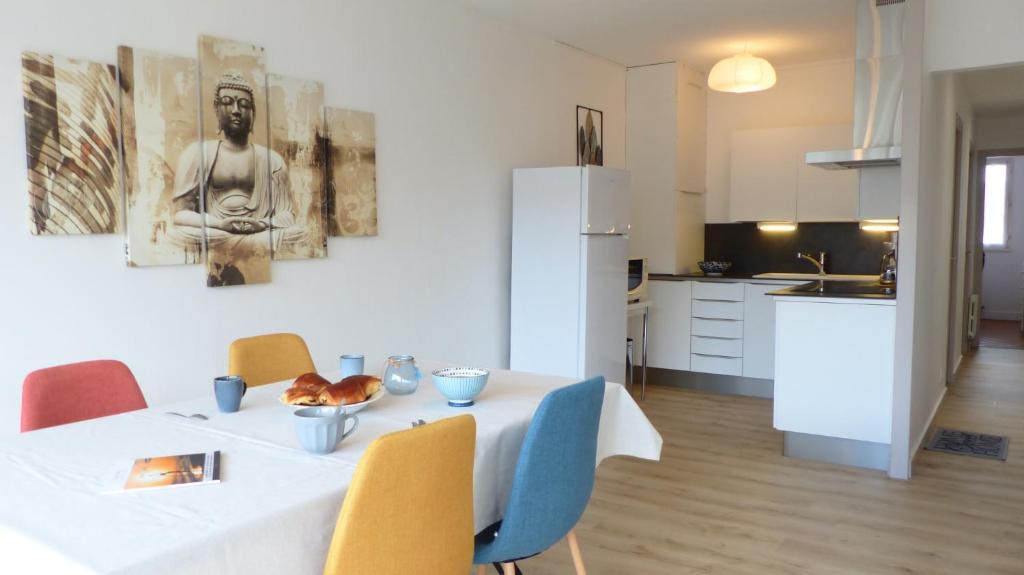 Un comedor con una mesa y sillas blancas. en Ti An Alré, appartement 4 p en centre ville, en Auray