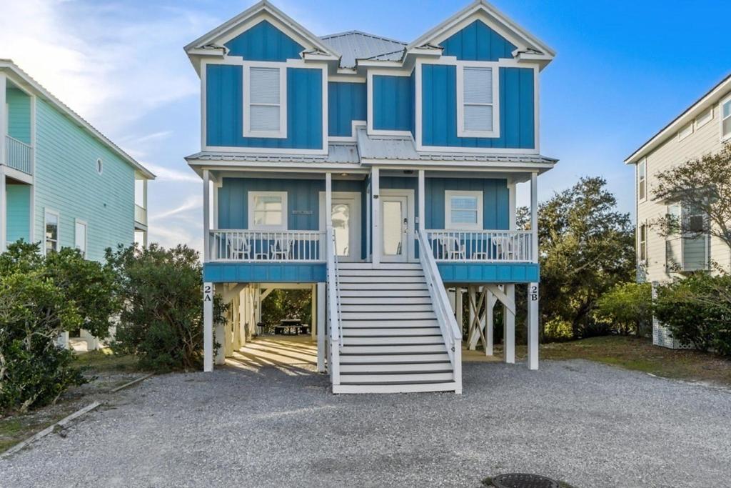 uma casa azul com escadas que levam até ela em Big Blue Cottage 2A em Gulf Shores