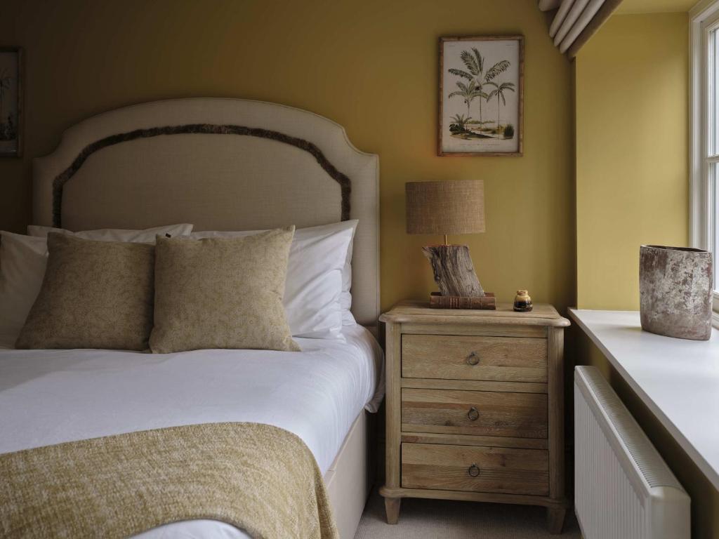 um quarto com uma cama e uma mesa de cabeceira com um candeeiro em Plum House em Haslemere