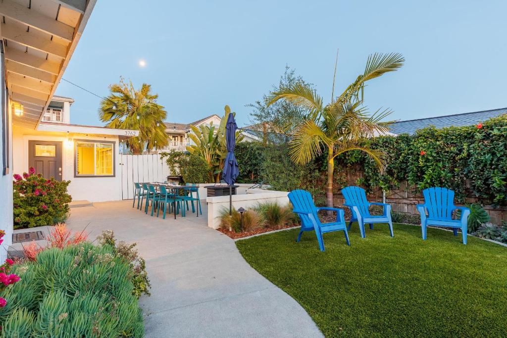 un patio con sedie blu e un tavolo in un cortile di Pet Friendly Beach Bungalow, Close to Beach a Carlsbad