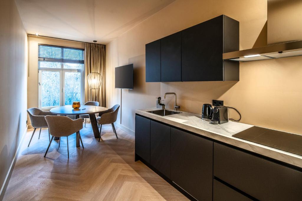 a kitchen with a sink and a table with chairs at Breda City Apartments in Breda