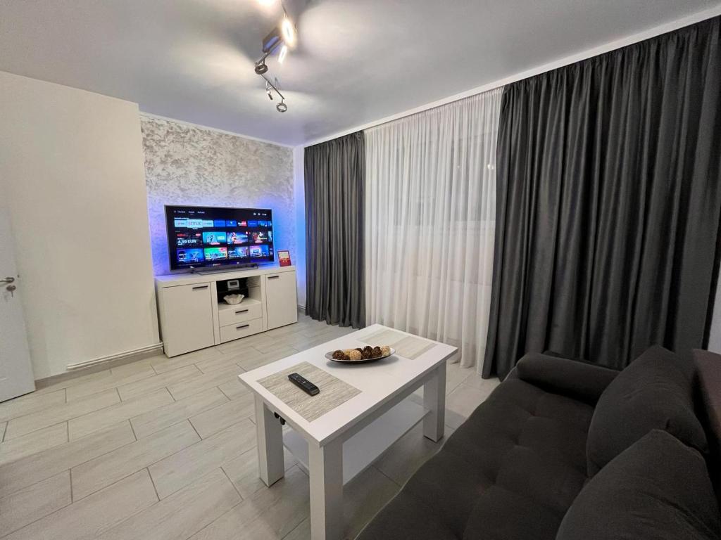sala de estar con sofá y TV en White & Elegant Luxury Apartament Decomandat, en Craiova