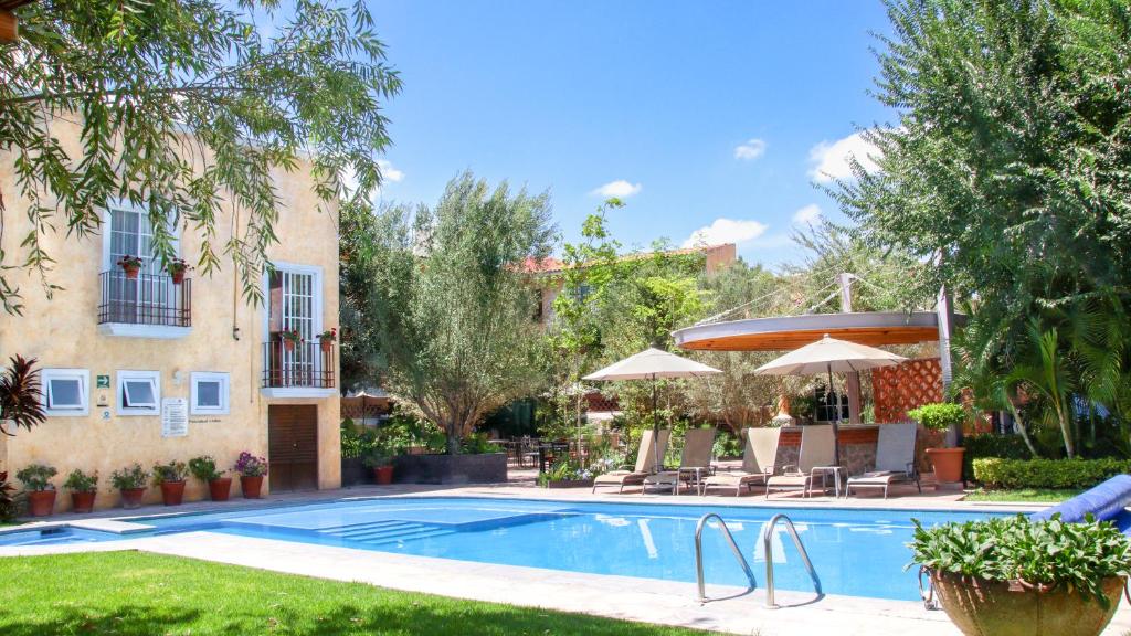 a swimming pool in a yard next to a building at Hotel Boutique La Granja in Tequisquiapan