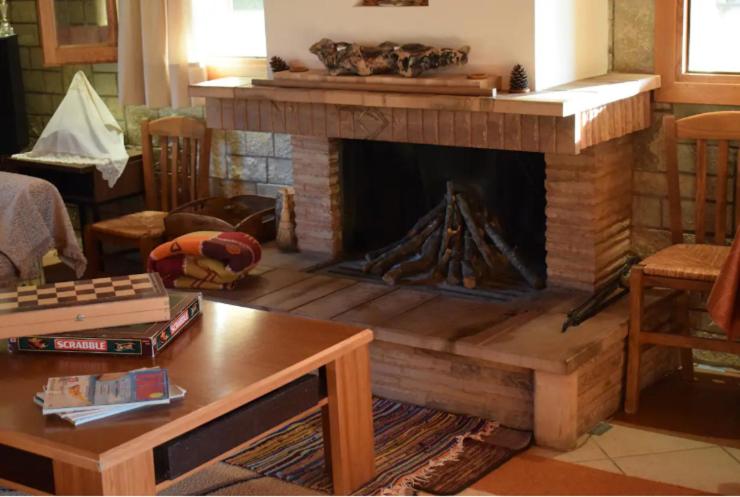 a living room with a fireplace with a table at Κτήμα Φτελιά in Avérnai