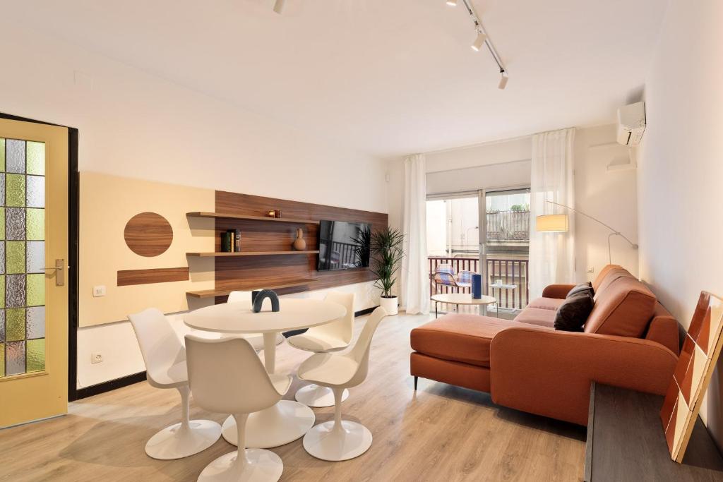 un soggiorno con divano, tavolo e sedie di Maria Poblenou Apartment by Olala Homes a Barcellona