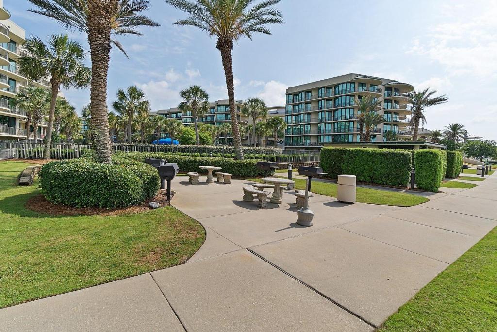 un parque con bancos y palmeras y un edificio en Phoenix On The Bay 1514, en Orange Beach