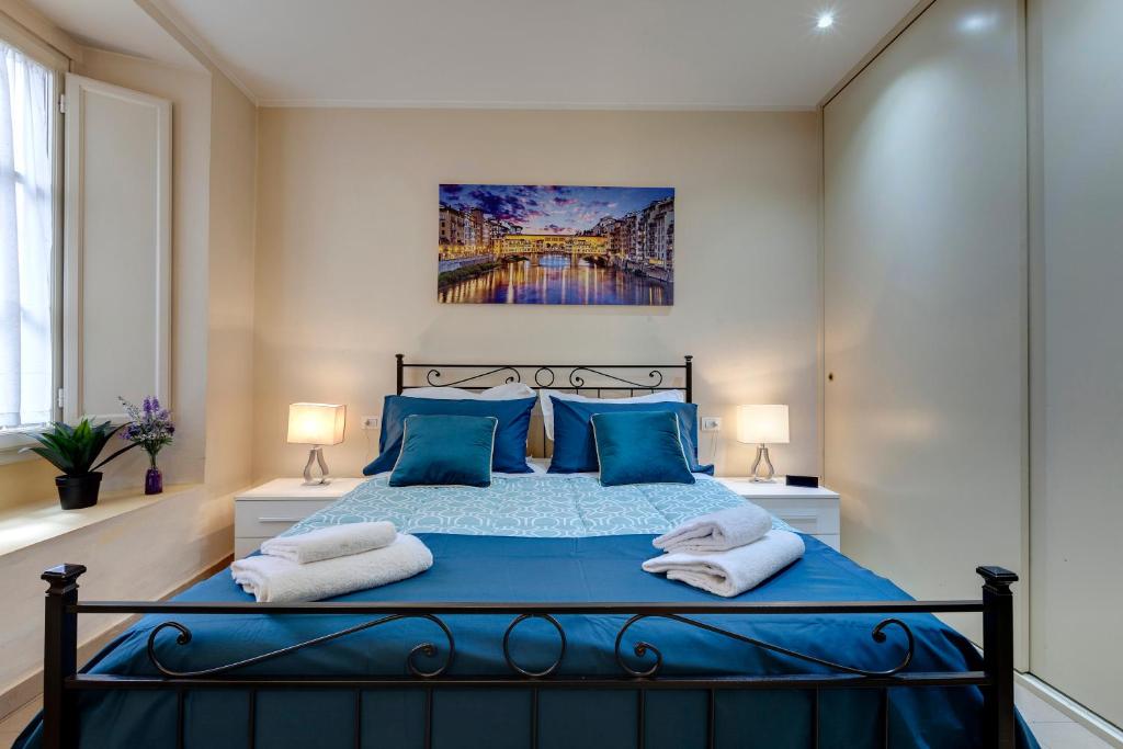 a bedroom with a blue bed with blue pillows at Golden House in Florence