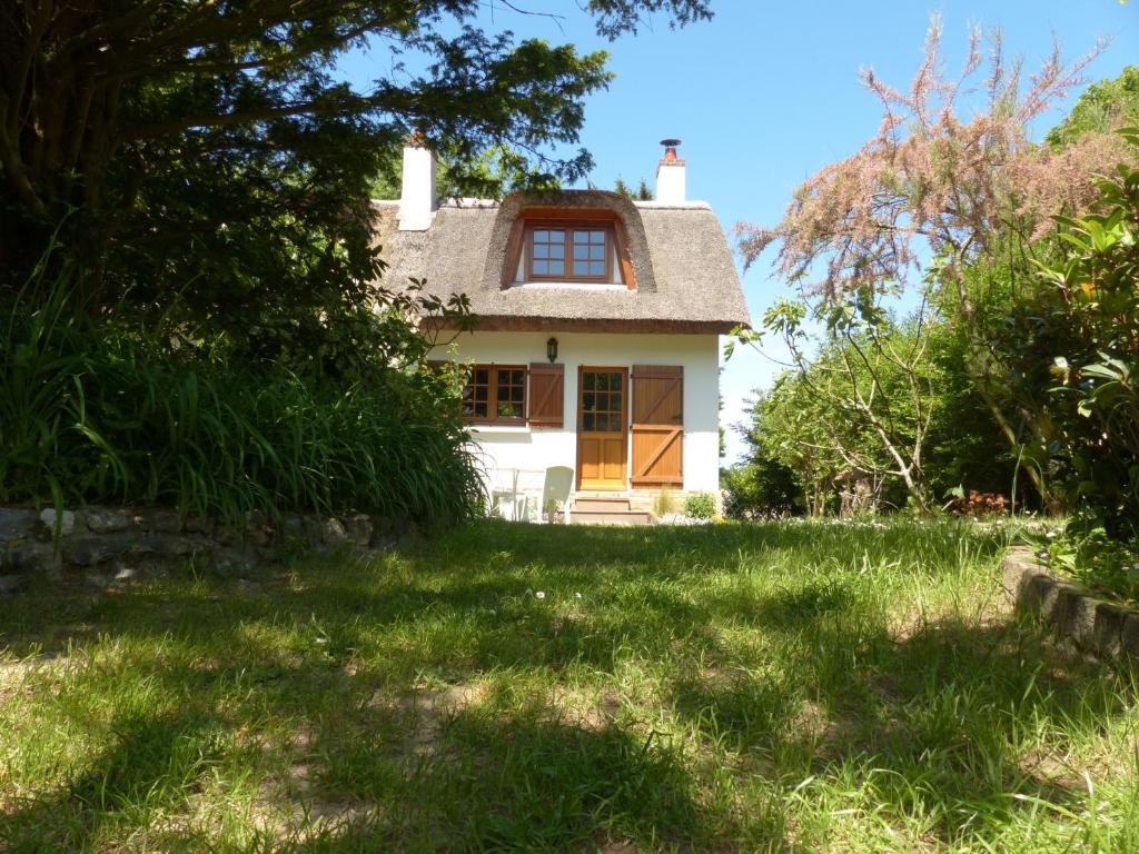 an old house in the middle of a yard at La Flore De Lys in Saint-Jouin-Bruneval