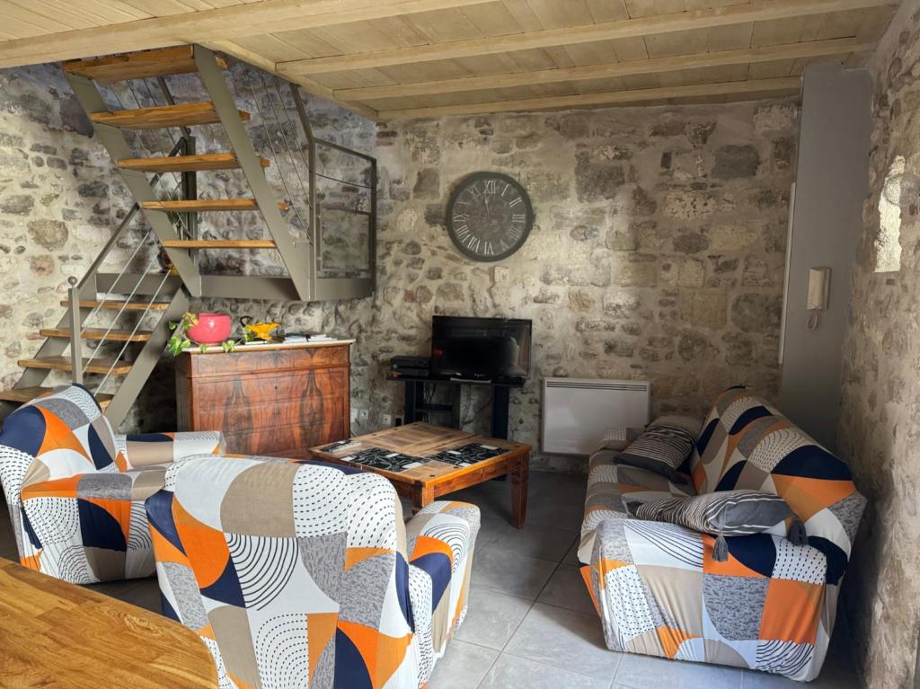 una sala de estar con 2 sofás y una escalera en Petite maison sur jardin secret, en Aviñón