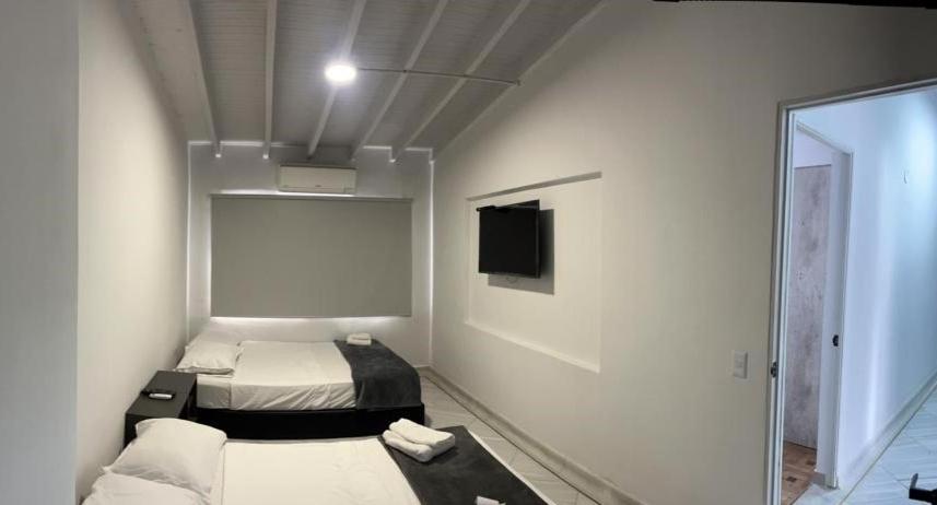 mały pokój z 2 łóżkami i lustrem w obiekcie Hotel la Carpita w mieście El Poblado