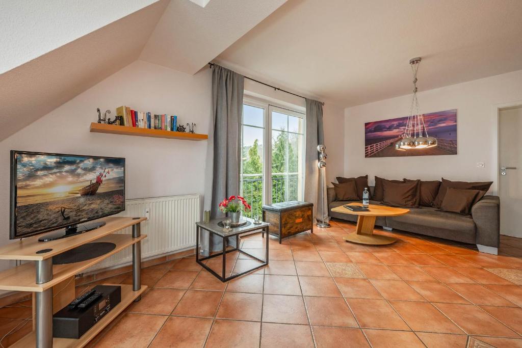 ein Wohnzimmer mit Sofa und Fernseher in der Unterkunft Villa Cölpin - Charlotte 03 in Ostseebad Kölpinsee
