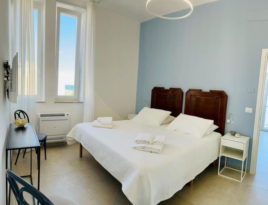 ein Schlafzimmer mit einem großen weißen Bett mit zwei Handtüchern darauf in der Unterkunft L'Ancora 2 in Giovinazzo