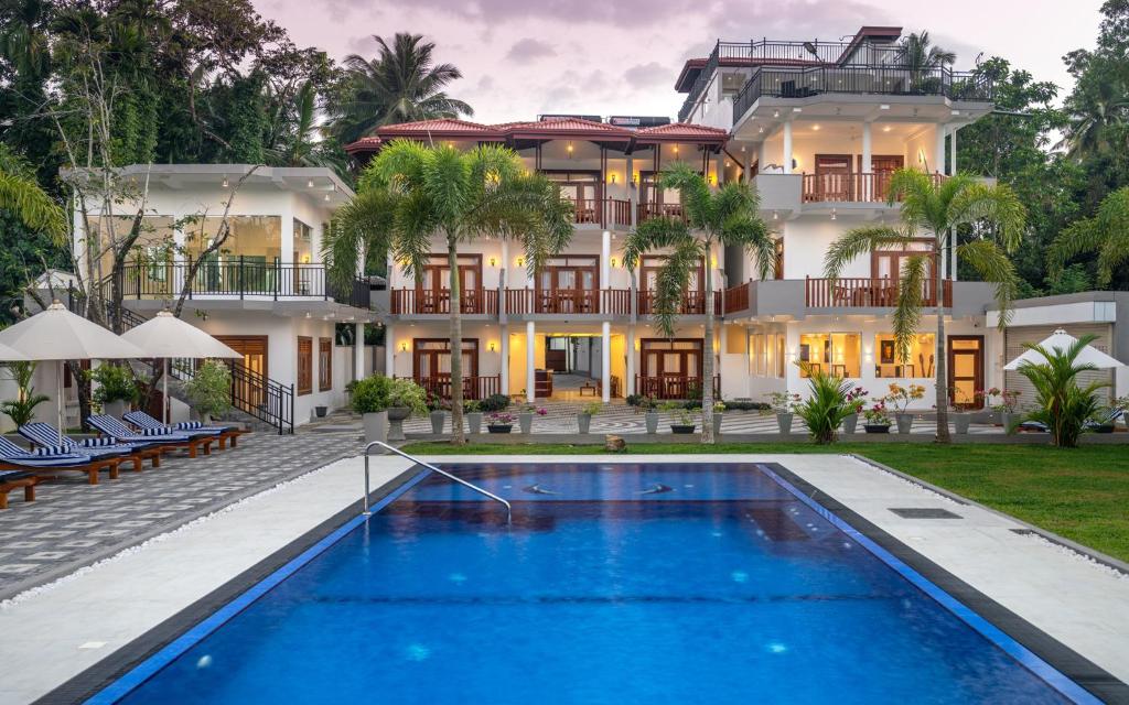 a hotel with a swimming pool in front of a building at Hotel Southern Blue Sapphire in Induruwa