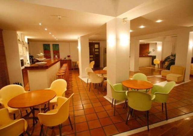 a room with tables and chairs and a kitchen at Hanioti hotel in Hanioti