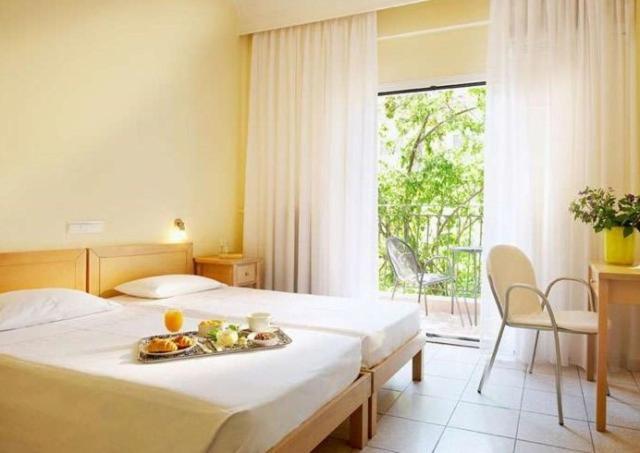 Una habitación de hotel con una cama con una bandeja de comida. en Hanioti hotel, en Chaniotis