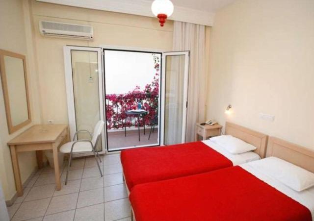 a hotel room with a red bed and a window at Hanioti hotel in Hanioti