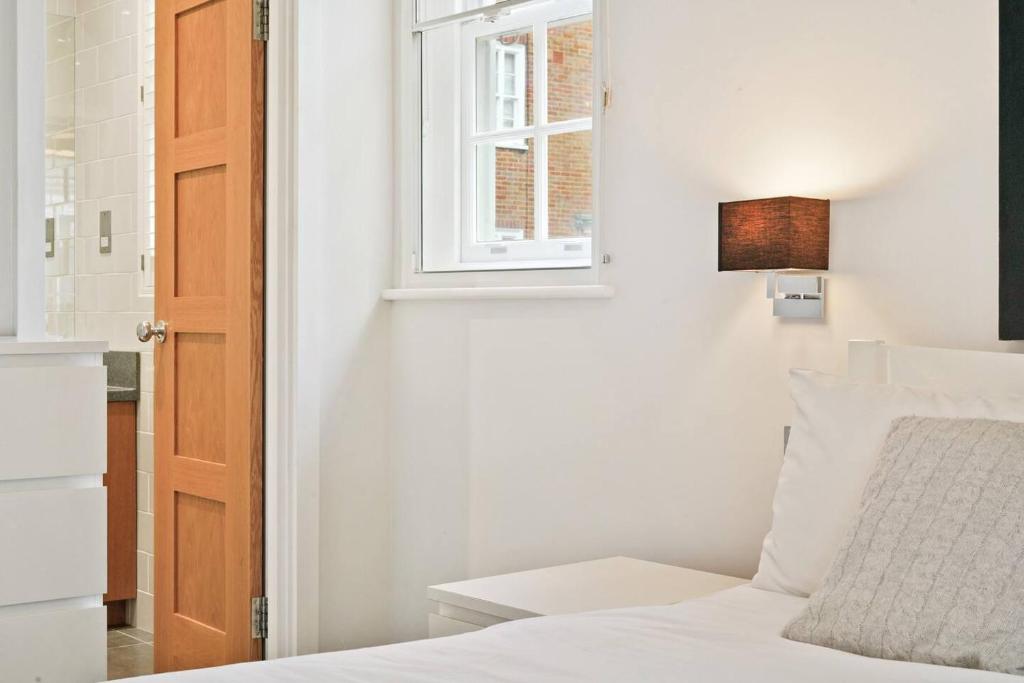 sypialnia z białym łóżkiem i oknem w obiekcie Chelsea Diamond w Londynie