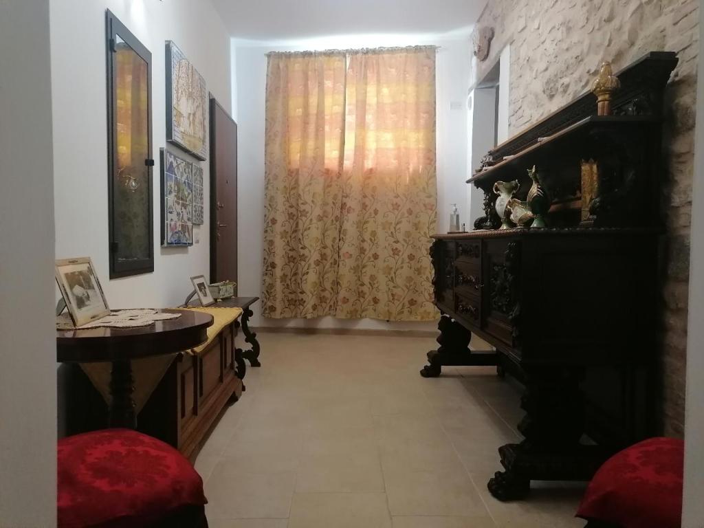 a living room with a piano and a window at Dimora Storica in Petrignano