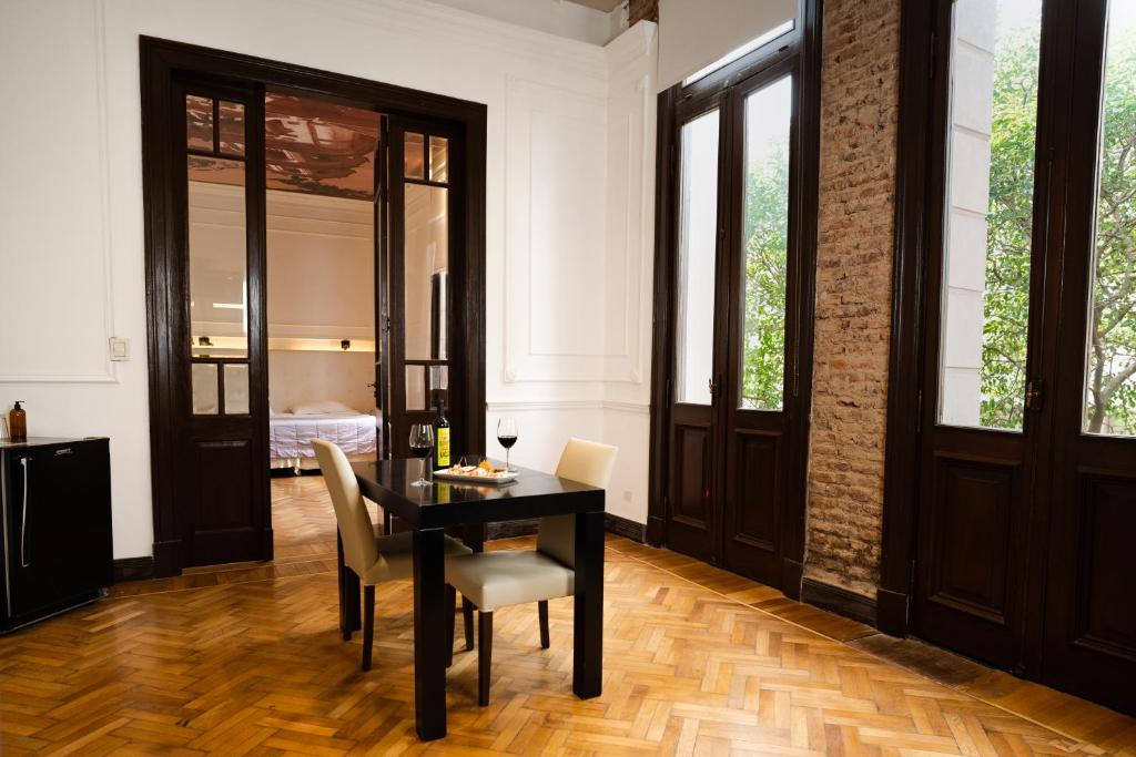 uma sala de jantar com uma mesa preta e cadeiras em Loft Osteria by Sagardi em Buenos Aires