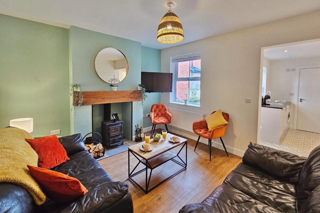 ein Wohnzimmer mit einem Sofa und einem Tisch in der Unterkunft Village Life, cosy yet spacious home in Oswestry