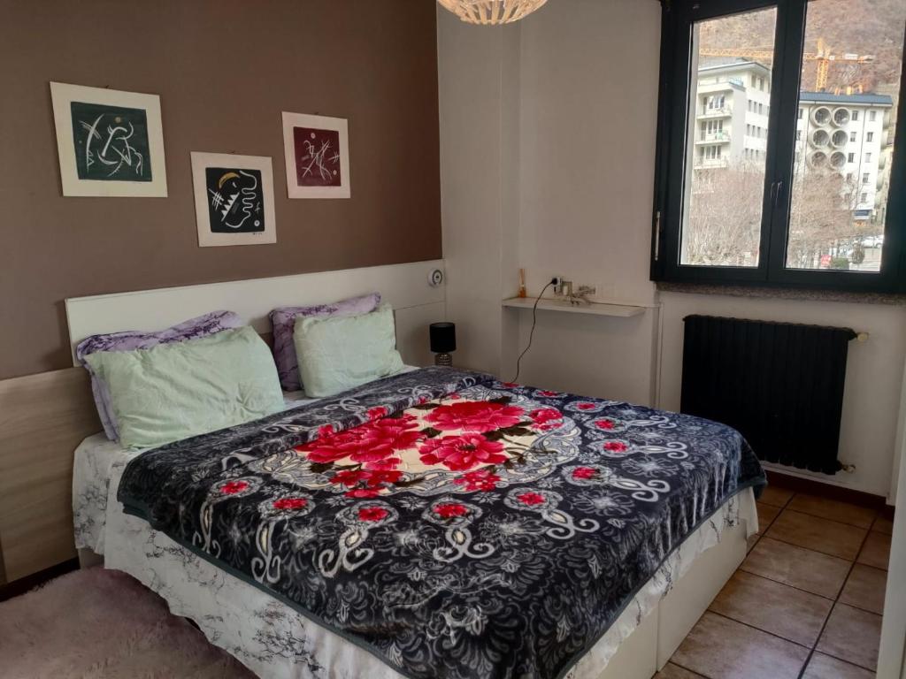 a bedroom with a bed with red roses on it at Bernina Station Center Appartment - Tirano in Tirano