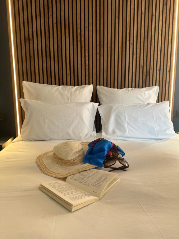 un chapeau et un livre sur un lit avec un chapeau et un livre dans l'établissement OVYO Hôtel, à Toulouse