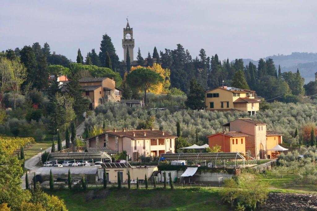 een stad met een klokkentoren op een heuvel bij Agriturismo Borgo Stella in Montespertoli