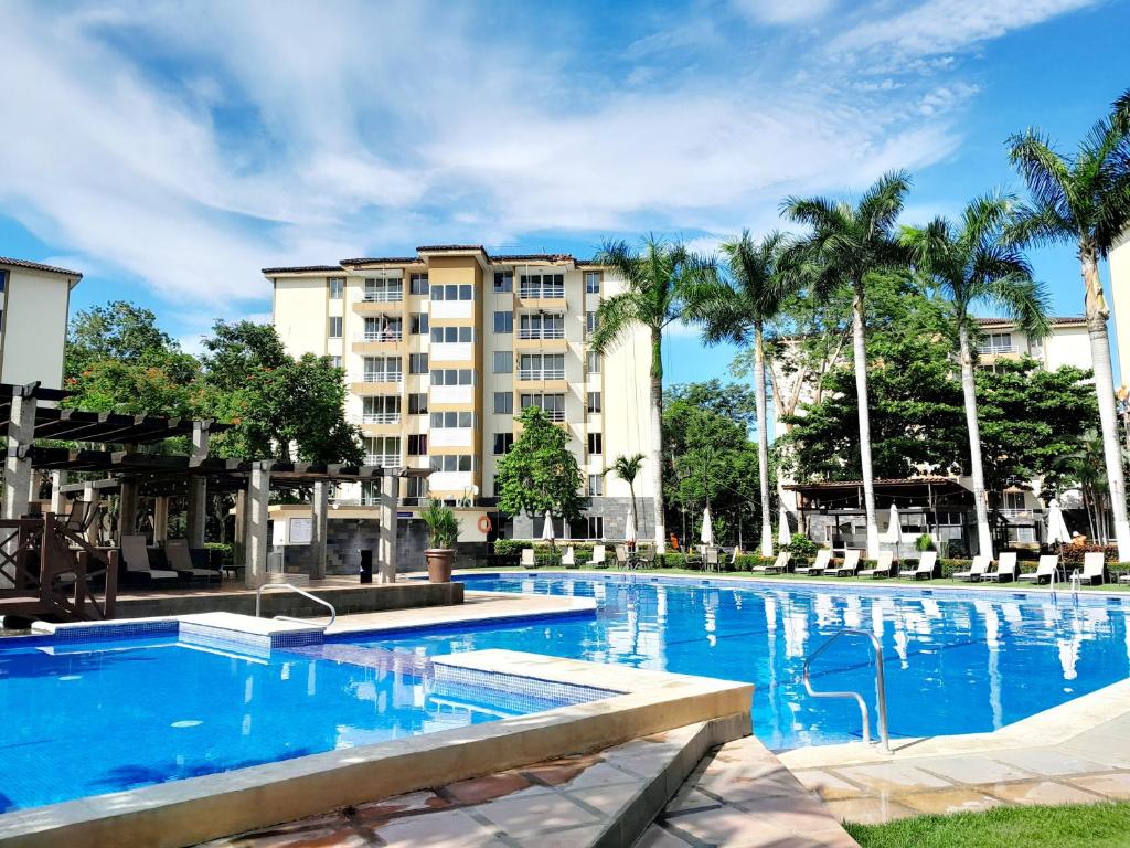 a large swimming pool in front of a building at Family condo, pool, beach and surf in Jacó